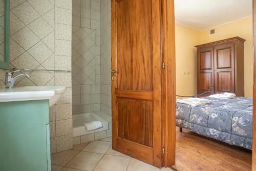łazienka z łóżkiem, umywalką i drzwiami w obiekcie Casa Girasole w mieście Roccastrada
