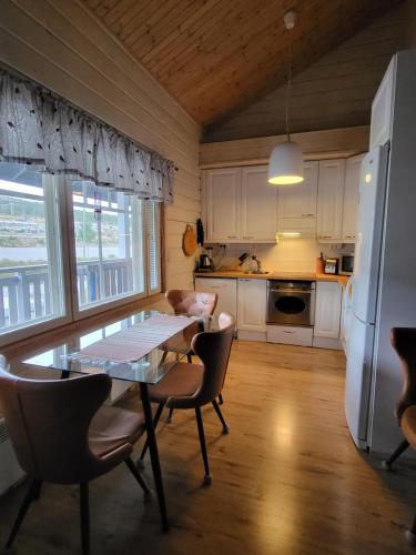 a kitchen with a table and chairs and a refrigerator at Ylläs slope SareStar in Ylläsjärvi