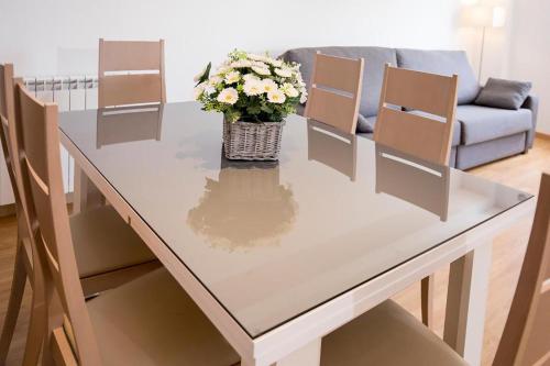 a table and chairs with a vase of flowers on it at The Lodge at Ribasol in Arinsal