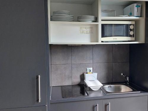 Una cocina con gabinetes blancos y un fregadero. en The Lodge at Ribasol, en Arinsal