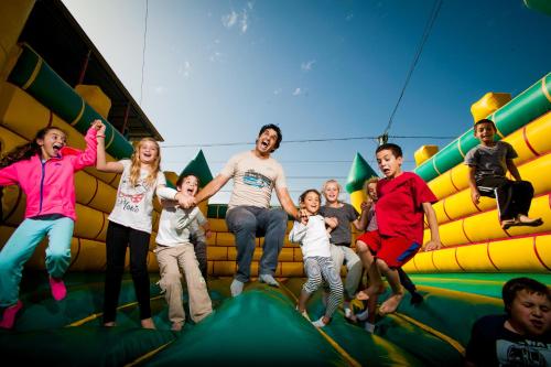 a group of people jumping on an infront of an indoor playground at Tzuba Hotel in Ẕova