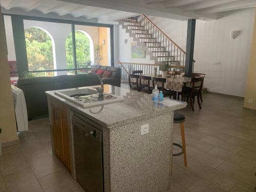 a kitchen and living room with a table and a staircase at Casa Carmen in Alájar