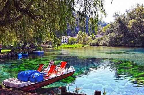 a boat with chairs on a river with trees at Casa Rosamari - su Lago di Posta Fibreno, Appartamento con camino in Posta Fibreno