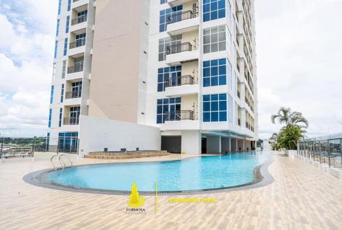 a swimming pool in front of a building at SLEPTOPIA at Formosa Residence - Apartment 70m2 with Best interior & View in town in Nagoya