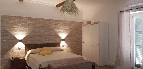 a bedroom with a bed and a brick wall at Casa Rosamari - su Lago di Posta Fibreno, Appartamento con camino in Posta Fibreno