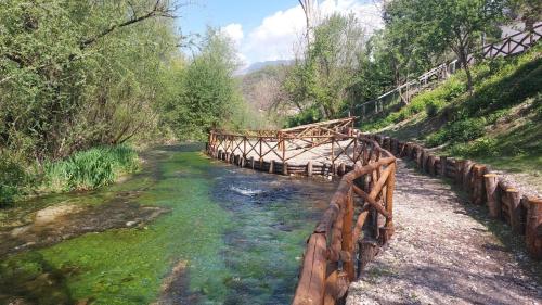 a wooden bridge over a stream in a forest at Casa Rosamari - su Lago di Posta Fibreno, Appartamento con camino in Posta Fibreno