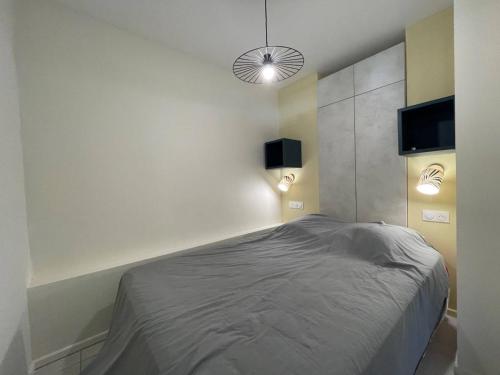 - une chambre avec un lit et deux lumières sur le mur dans l'établissement Studio Cabine à 400m de la Plage, Rénové, Clim, Parking, 4 Couchages, TV, Lave-linge, Lave-vaisselle - FR-1-225-679, à Argelès-sur-Mer
