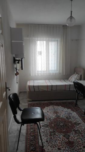 een kamer met een bed, een stoel en een raam bij Kuskayasi Apart 