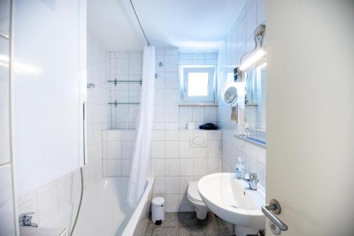 La salle de bains est pourvue d'un lavabo, d'une baignoire et de toilettes. dans l'établissement Apartment mit Balkon und Festungsblick, à Wurtzbourg