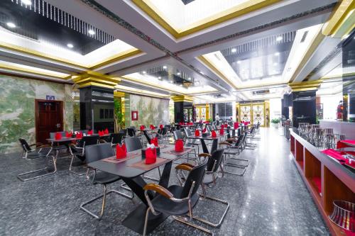 uma sala de jantar com mesas e cadeiras com guardanapos vermelhos em Khách sạn INCO 515.9 em Phủ Lý