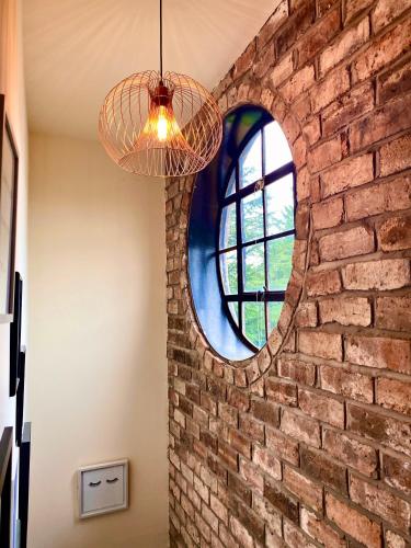 a brick wall with a circular window in a room at Private Loft Country Hideaway in Shifnal