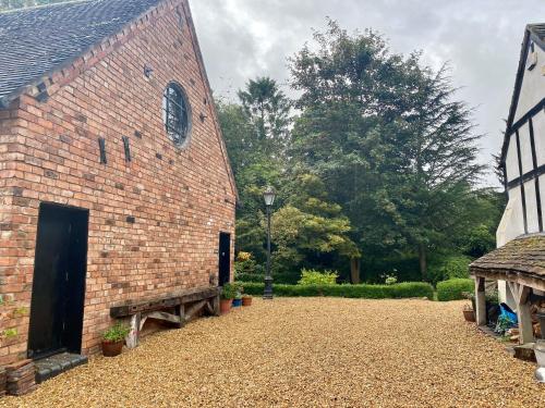 a brick building with a door and a bench at Private Loft Country Hideaway in Shifnal