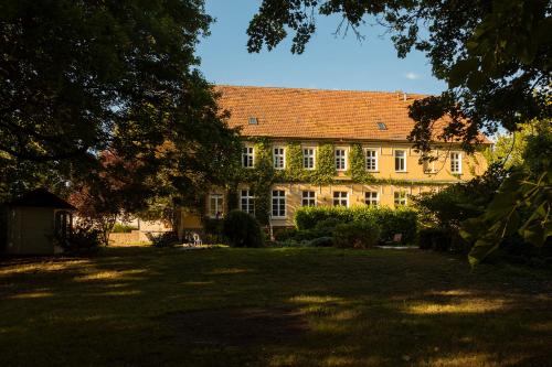 a large yellow building with a red roof at Gutshauszimmer Doppel Neu Gaarz in Neu Gaarz