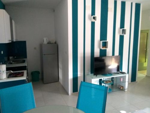 a living room with blue chairs and a television at Apartment Tara in Sumartin
