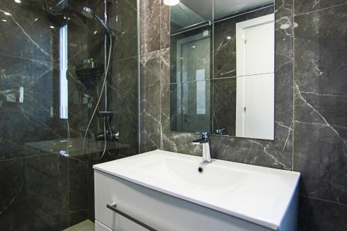 een badkamer met een wastafel en een spiegel bij Phaedrus Living: Luxury Suite Nicosia 501 in Nicosia
