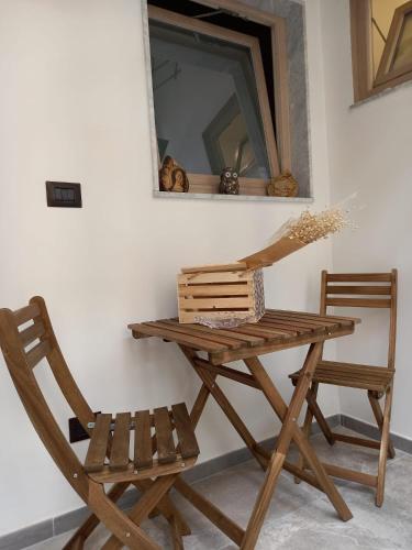 een houten tafel, een stoel en een spiegel bij Maga Mirò - Guest House in Salerno