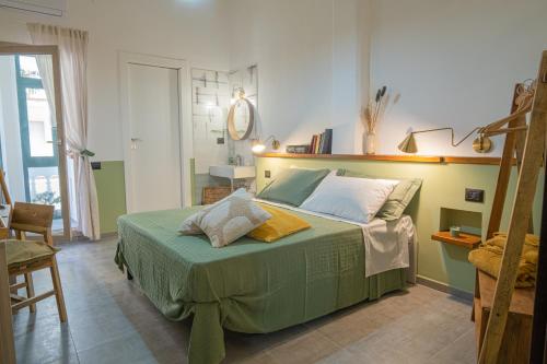 um quarto com uma cama grande e um cobertor verde em Maga Mirò - Guest House em Salerno