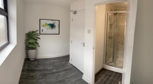 a hallway with a shower and a potted plant at The Aintree - By CHAPS in Aintree