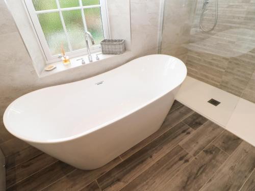 a white bath tub in a bathroom with a window at 1 Claire House Way in Barnard Castle