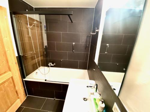 a bathroom with a tub and a sink and a mirror at Chesery 1 in Morgins