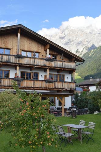 a large building with a table and chairs in front of it at Hotel zum Urviech -Erwachsenenhotel- in Ehrwald