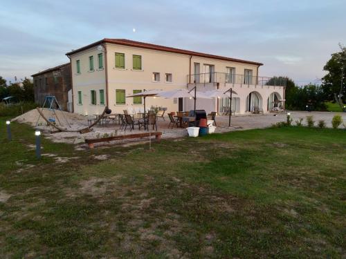 a large building with a table and chairs in a yard at Ca' Vascon Alloggio Agrituristico in Villa Estense