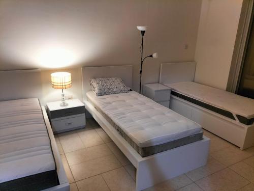 a bedroom with two beds and a lamp in it at Amazing apartment 2 bed rooms in Tecom 6 pax in Dubai