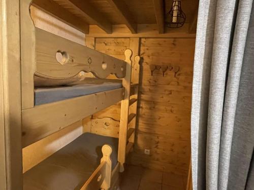 a room with a bunk bed in a wooden cabin at Appartement Praz-sur-Arly, 1 pièce, 6 personnes - FR-1-603-47 in Praz-sur-Arly