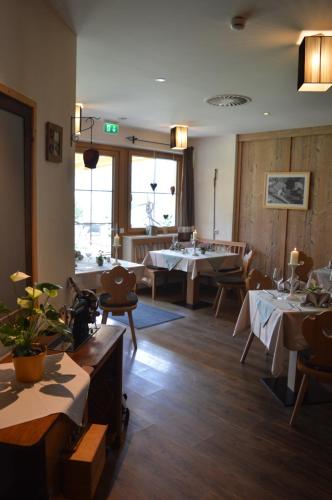 a restaurant with tables and chairs in a room at Hotel zum Urviech -Erwachsenenhotel- in Ehrwald