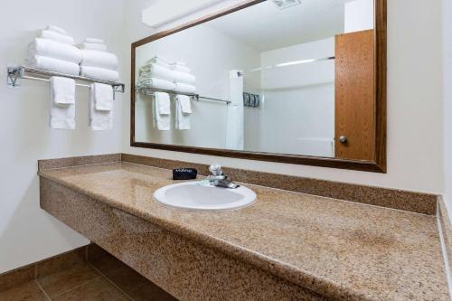 a bathroom with a sink and a mirror and towels at Baymont by Wyndham Bozeman in Bozeman