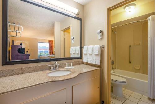 a bathroom with a sink and a toilet and a mirror at Baymont by Wyndham Columbus GA in Columbus