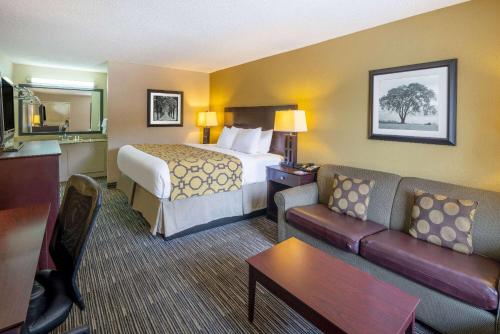 a hotel room with a bed and a couch at Baymont by Wyndham Columbus GA in Columbus