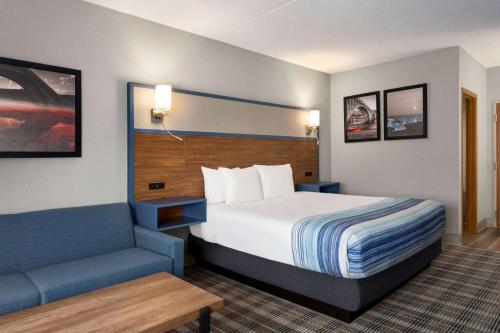 a hotel room with a bed and a couch at AmericInn by Wyndham Branson & Conference Center in Branson