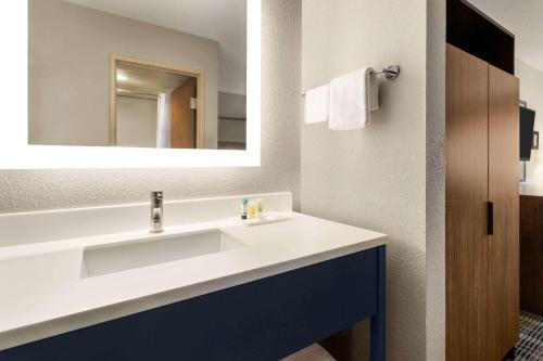 y baño con lavabo blanco y espejo. en AmericInn by Wyndham Branson & Conference Center en Branson