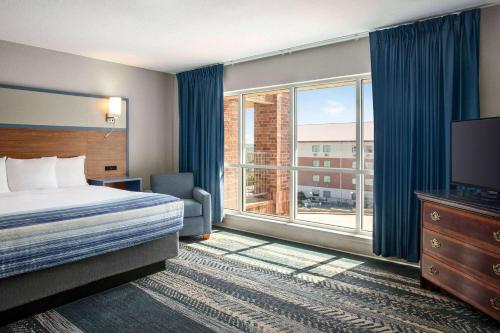 a hotel room with a bed and a large window at AmericInn by Wyndham Branson & Conference Center in Branson