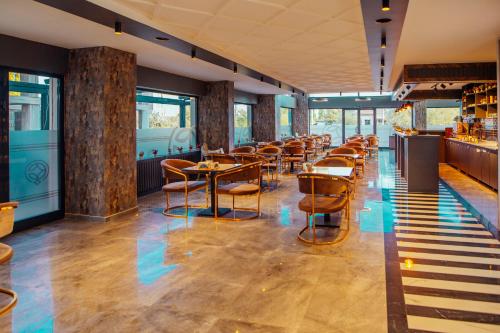 un restaurant avec des tables et des chaises en bois ainsi que des fenêtres dans l'établissement GRAND ÇAKIROĞLU HOTEL, à Aksaray