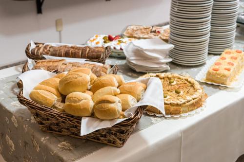 a table topped with baskets of bread and pies at Condall Palace Hotel in Nova Prata