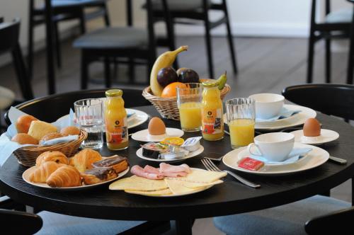 una mesa con comida para el desayuno y bebidas en ella en Het Rustpunt en Gante