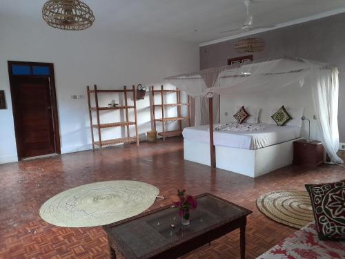a living room with a bed and a table at Culture's apartment in Paje