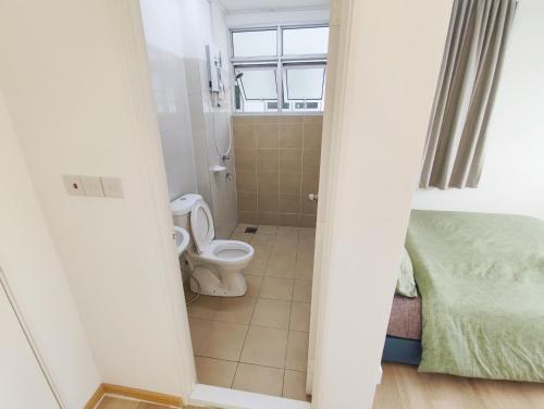 a small bathroom with a toilet and a bed at Muji homestay kuching scenic view 2 bedrooms entire apartment in Kuching