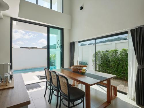 a dining room with a table and chairs and a large window at Casa de Yim, Eco Pool Villa in Ao Nang Beach