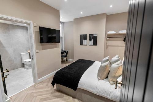 a bedroom with a large bed and a bathroom at The Burlington by STAMP SA in Blackpool