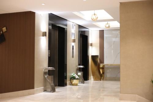 een hal met een badkamer met een wastafel en een spiegel bij Rahhal Hotel Suites in Yanbu