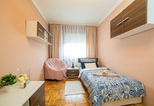 een slaapkamer met een bed, een stoel en een raam bij Sunny day -Arena Zagreb , 2 bathrooms, 102m², in Zagreb