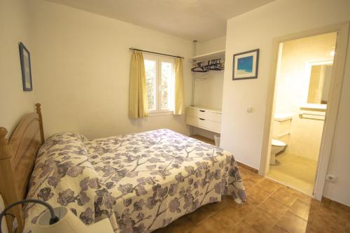 a bedroom with a bed and a bathroom at Villa Garbes in Cala Galdana