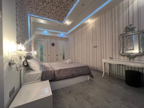 a bedroom with a bed and a mirror and a sink at Megafun Luxury Family Apartment in Baku