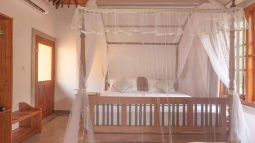 a bedroom with a bed with a canopy at Birds Paradise Cabanas Unawatuna in Unawatuna