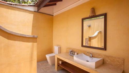 a bathroom with a sink and a toilet at Birds Paradise Cabanas Unawatuna in Unawatuna