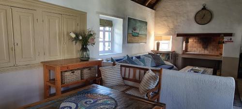 a living room with a couch and a table at Casa Pescador Beach House in Struisbaai