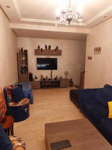 ein Wohnzimmer mit einem Sofa und einem Flachbild-TV in der Unterkunft Bouskoura, Joli appartement coup de cœur in Bouskoura